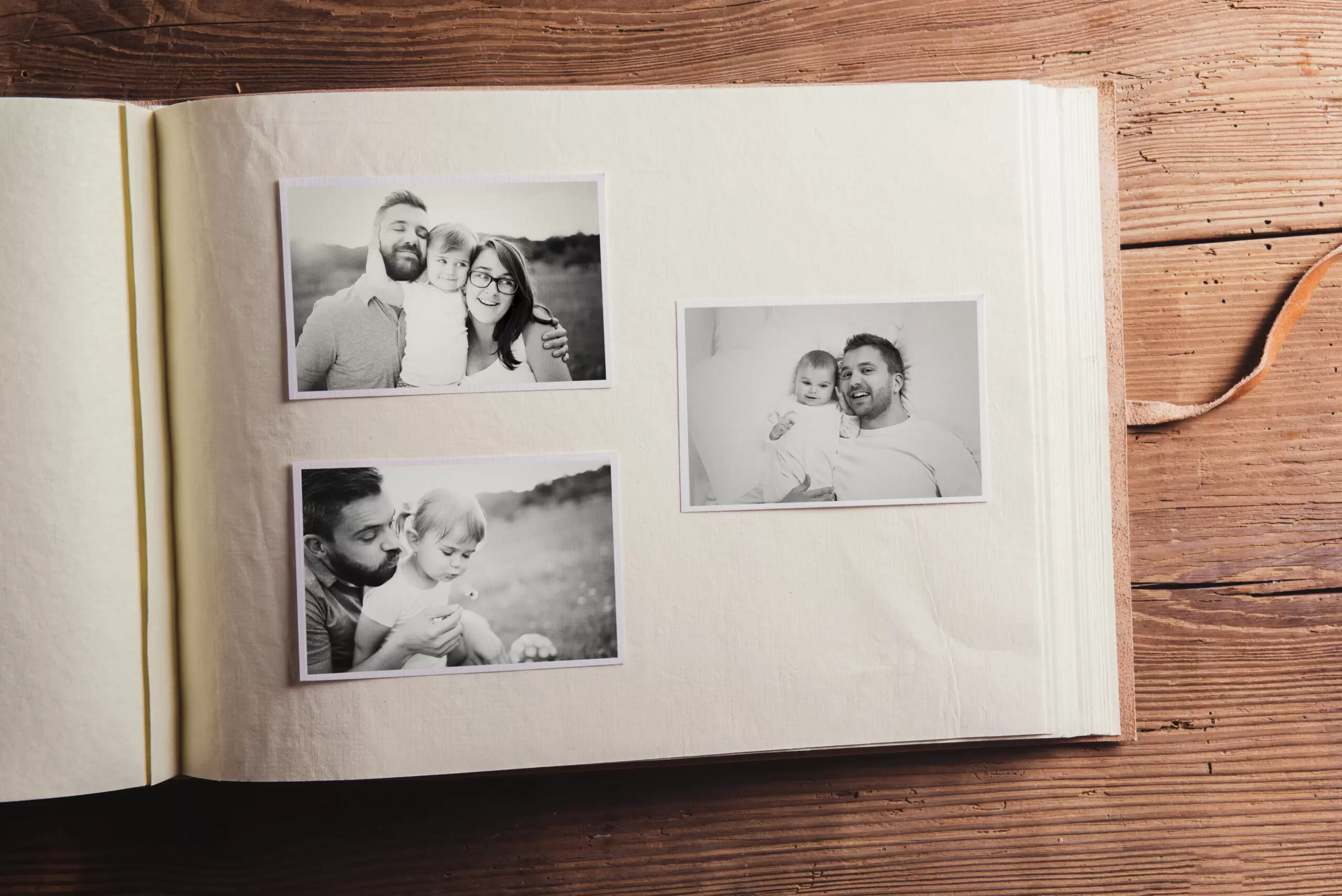 graphicstock-photo-album-with-black-and-white-family-pictures-studio-shot-on-wooden-background_SA2fM3T-Z-scaled