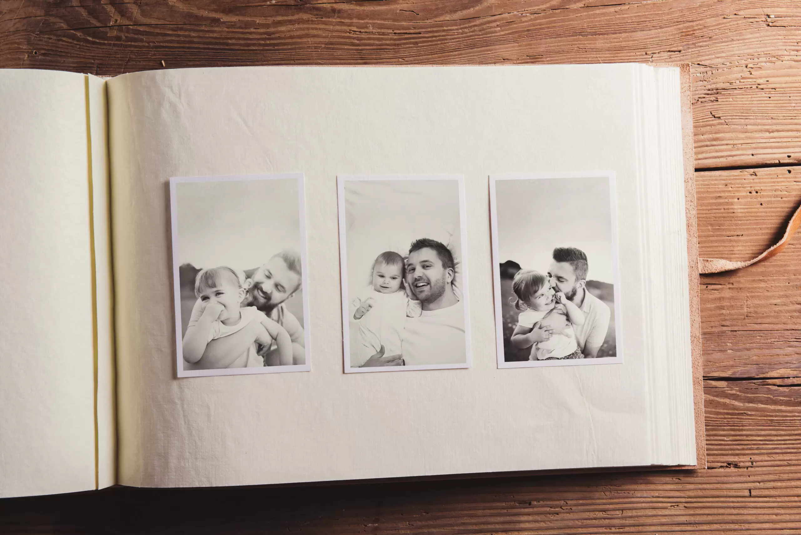 graphicstock-photo-album-with-black-and-white-family-pictures-studio-shot-on-wooden-background_SAliVMhp-W-scaled